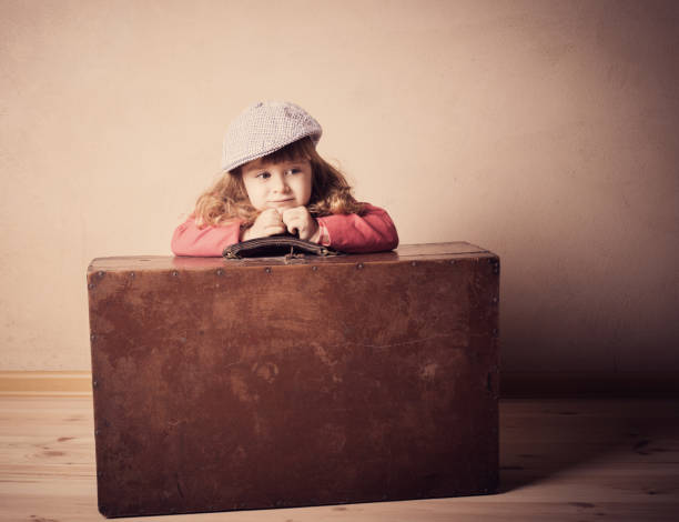 little girl with suitcase indoor