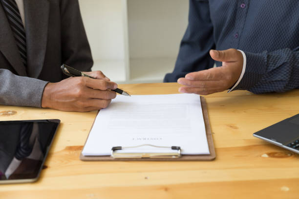 istock businessman with a contract giving a hand - presenting & signing business document with partner 674807218