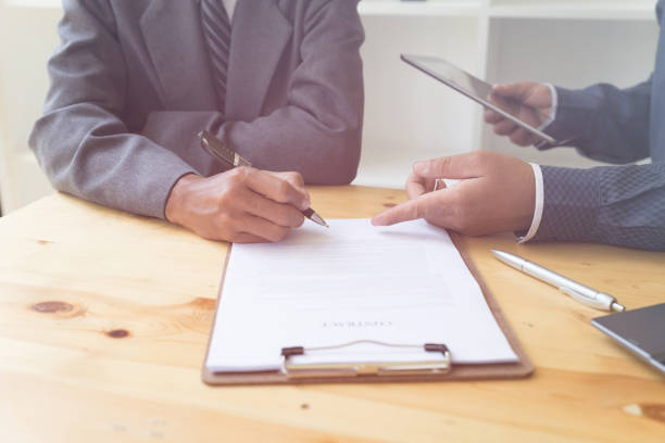 istock businessman poting his finger at contract - presenting & signing business document with partner 674807220