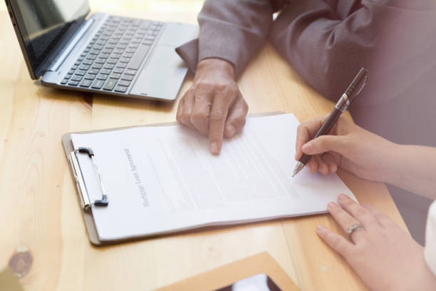 istock Person's hand hold ballpoint pen writing on  agreement paper sheet, fill in document template, applying for mortgage loan 674807258
