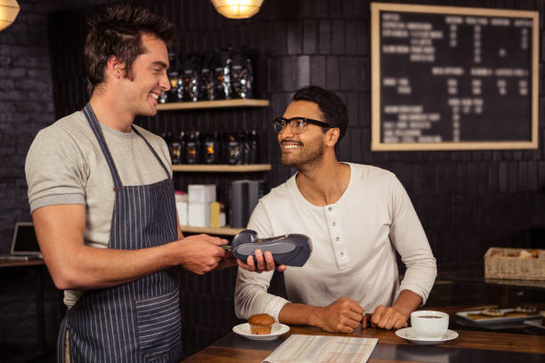 man paying his coffee with credit card - job search newspaper coffee shop cafe imagens e fotografias de stock