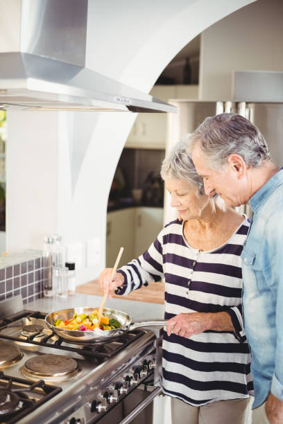 istock Senior couple cooking food in kitchen 674821710