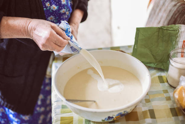 istock Grandmother pouring milk into pancake batter 674826770