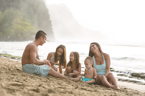 Family playing on beautiful sandy Hawaii beach