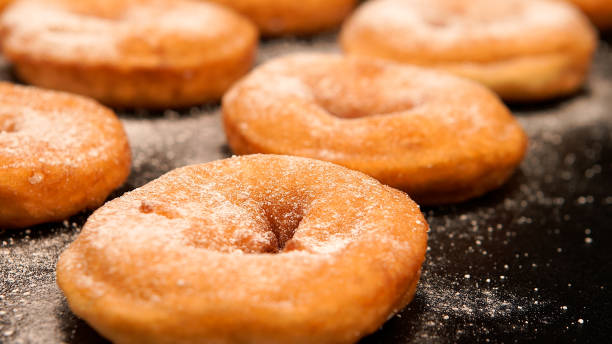 istock Sugar powder on a doughnuts on the black desk 674833536