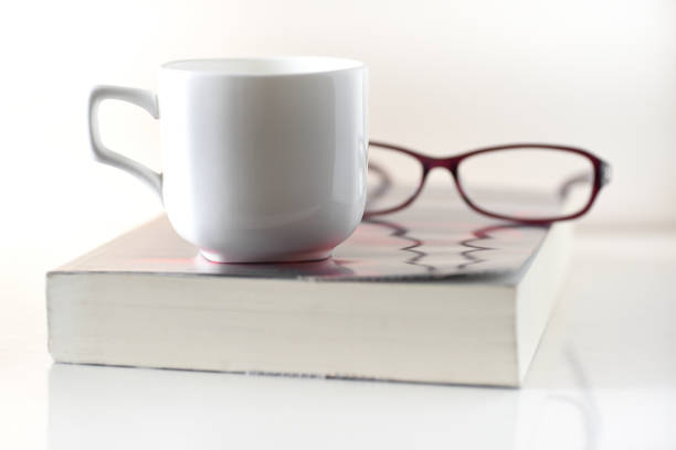 istock Cup of coffee,book and glasses on white background 674836492