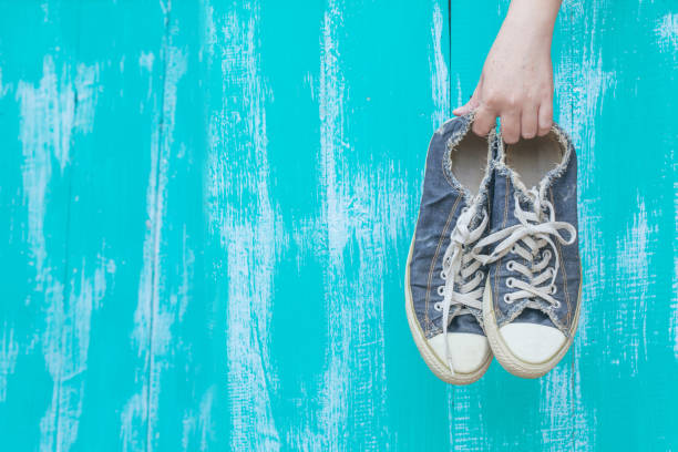 istock hand holding a dirty shoe 674851132