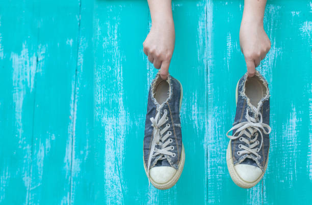 istock hand holding a dirty shoe 674851138