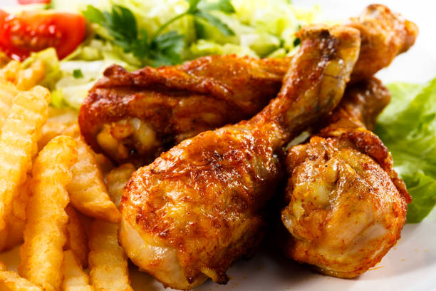 istock Grilled chicken legs with chips and vegetables 674851256