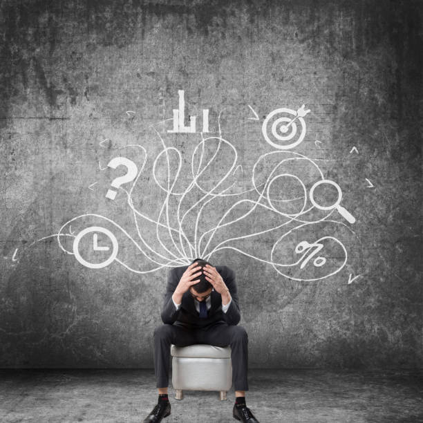 istock Stressed businessman sitting in front of wall 674857300