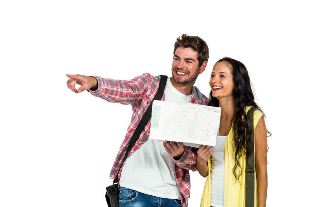 sonriente pareja manteniendo el mapa mientras apuntando en algún lugar - tourist map men holding fotografías e imágenes de stock