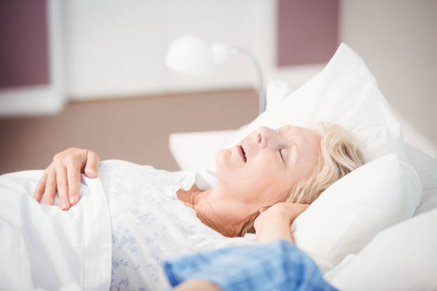 istock Woman snoring on bed next to husband 674866718