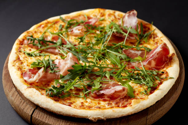 istock Hot pizza Prosciutto on a rustic wooden table. 674873510