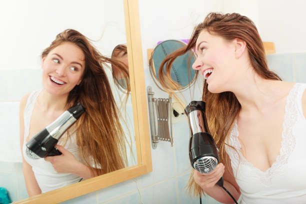istock long haired woman drying hair in bathroom 674893506