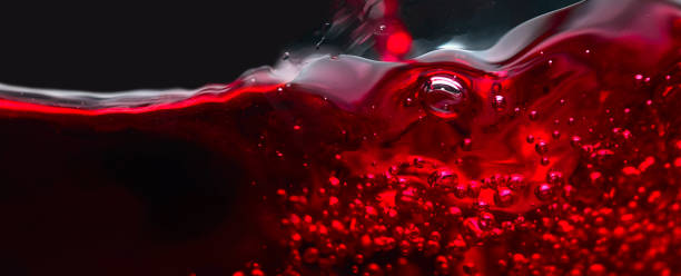 istock Abstract splashes of red wine on a black background 674902534
