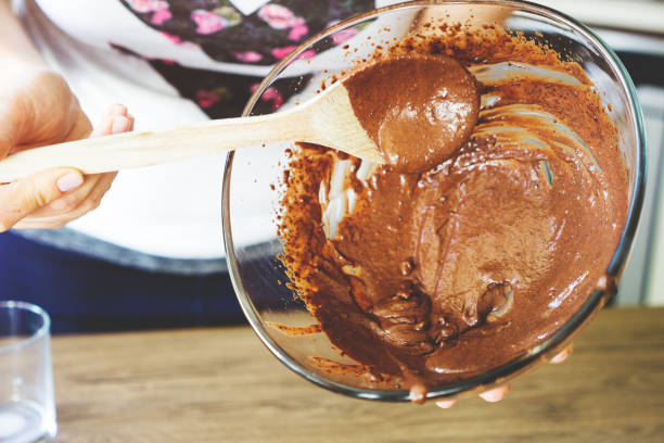 istock Making Cake - Pouring cake batter with wooden spoon 674906474