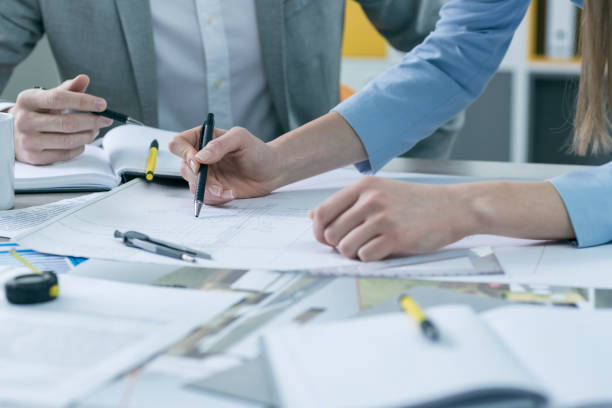 istock Close-up, coworkers hands on documents and blueprints at office 674909748