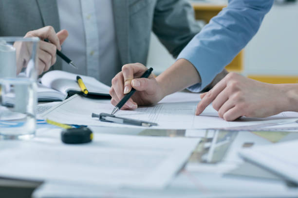 istock Close-up, coworkers hands on documents and blueprints at office 674909832