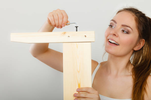 istock Woman assembling wooden furniture. DIY. 674910522