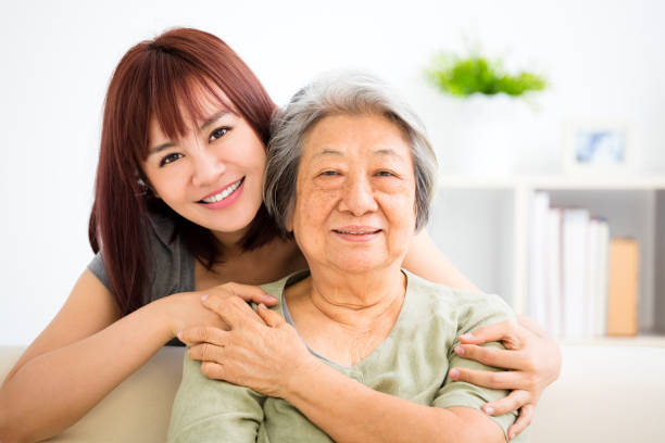 Grandmother and granddaughter. Young woman carefully takes care of old woman Grandmother and granddaughter. Young woman carefully takes care of old woman china chinese ethnicity smiling grandparent stock pictures, royalty-free photos & images