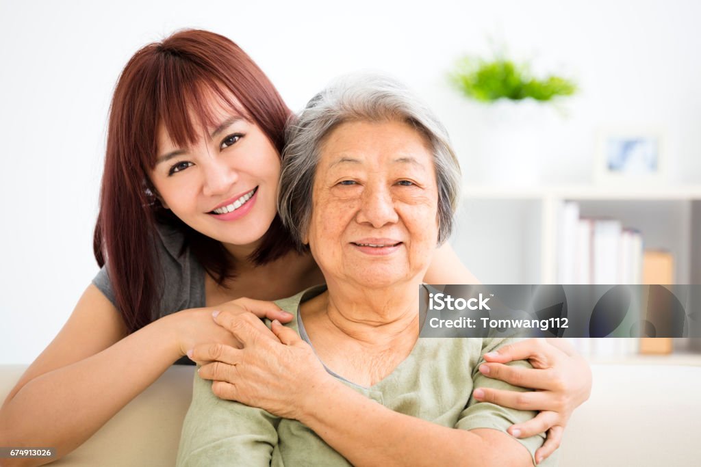 Avó e neta. Jovem mulher cuidadosamente cuida de velha - Foto de stock de Terceira idade royalty-free