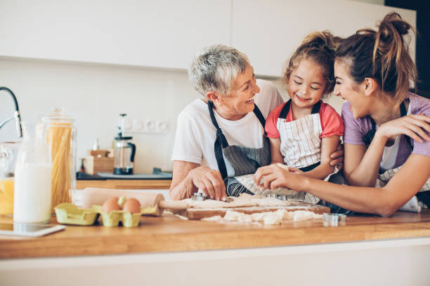 schöne kleine mädchen kochen mit mama und oma - grandmother cooking baking family stock-fotos und bilder