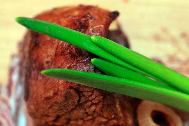 Roast red beef meat bbq bloc served on black plate with green chives