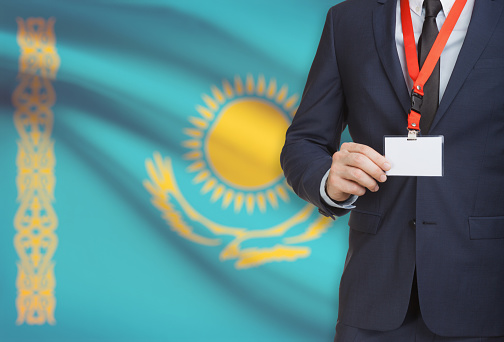 Businessman holding name card badge on a lanyard with a flag on background - Kazakhstan
