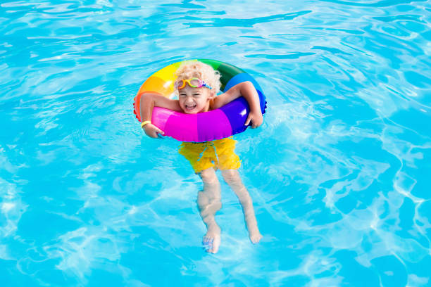 istock Child with toy ring in swimming pool 674937754