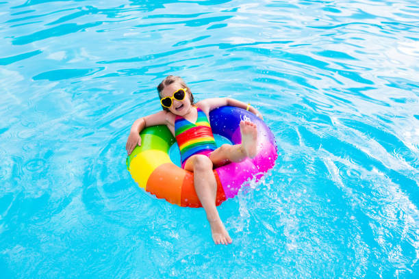 istock Child with toy ring in swimming pool 674938206