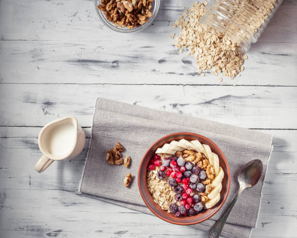 istock Oatmeal in bowl with berries, bananas and walnuts 674942524