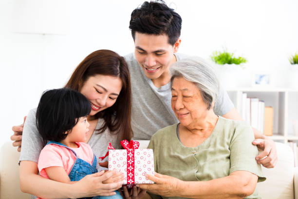 bambina felice dando regalo a sua nonna - grandmother giving gift child foto e immagini stock