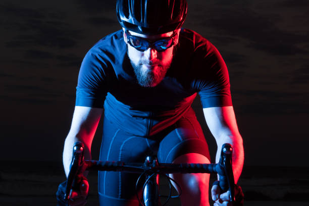 Colorful athlete bicyclist Portrait of athlete on bicycle with blue and red gels red white blue bike stock pictures, royalty-free photos & images