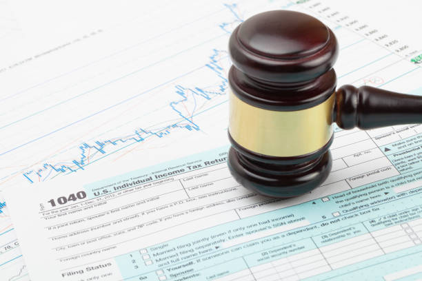istock Wooden judge's gavel and calculator over some financial documents 674958984