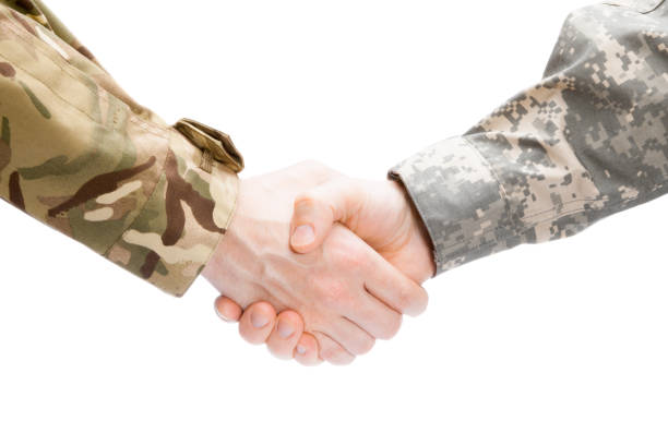 istock Two military men shaking hands on white background - close up studio shot 674959202