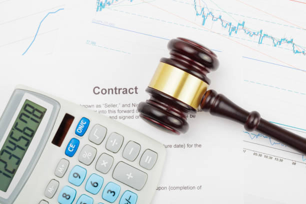 istock Wooden judge's gavel and calculator over some financial documents 674959296