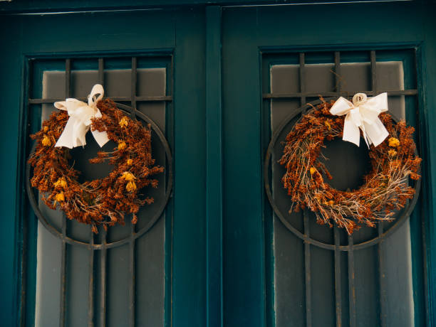istock Two brown wreaths with bows on green doors 674962980