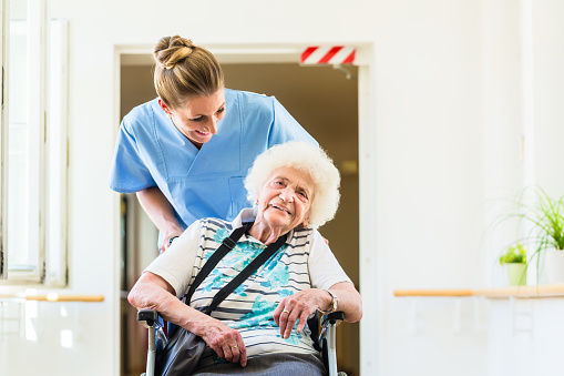 Caregiver with senior patient in wheel chair