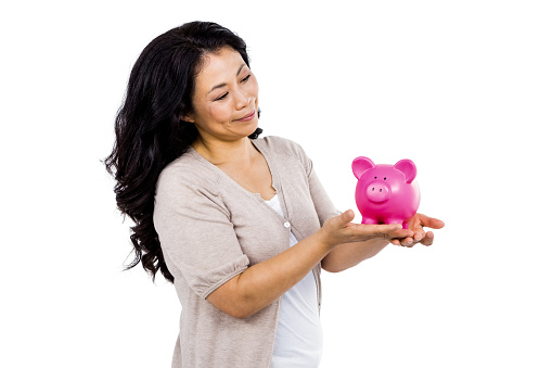 Happy woman holding a pink piggy bank