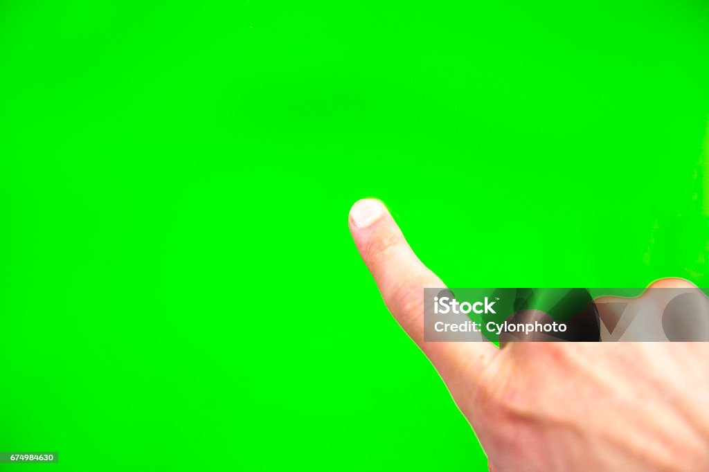 Digital green screen man hand Young man types and slides on a computer screen. Digital screen with chroma key screen - green screen. Male hand. Green Screen Stock Photo