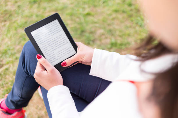 istock Attractive young woman with e-book/tablet in the park 674984724