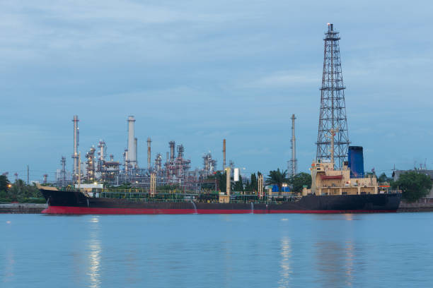 istock Oil refinery river side with boat tank 674987614