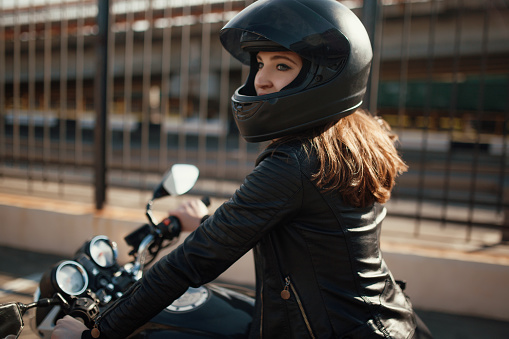 Cute young brunette woman and motorcycle on street