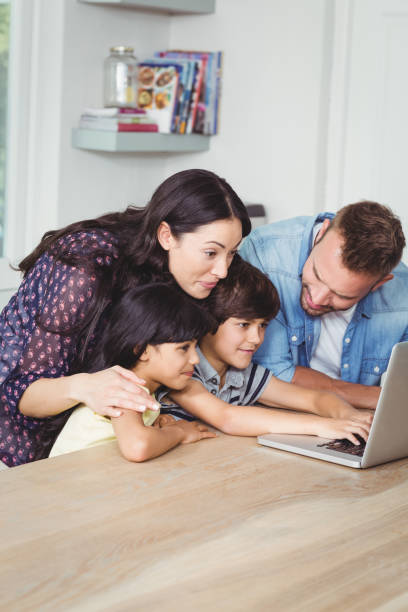 istock Smiling family using laptop together 674997754