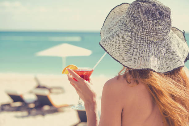 jeune femme de vue de dos portant un bikini appréciant la vue de l’océan. concept de voyage de vacances d’été - outdoor chair beach chair umbrella photos et images de collection