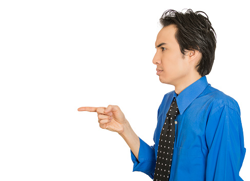 Closeup side view profile portrait serious man, pointing with index finger at someone, isolated white background space to left. Negative emotion facial expression feeling sign. Conflict resolution