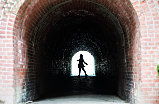 Silhouette of female in the red brick tunnel, Japan