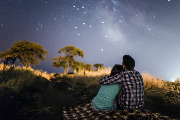 couple in love under stars of milky way galaxy - astronomia imagens e fotografias de stock