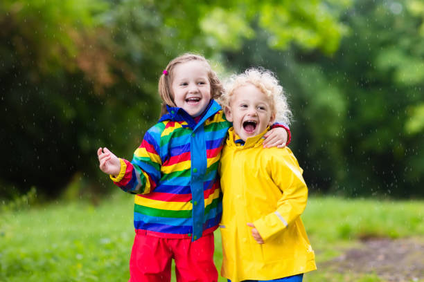 istock Kids play in rain and puddle in autumn 675009798