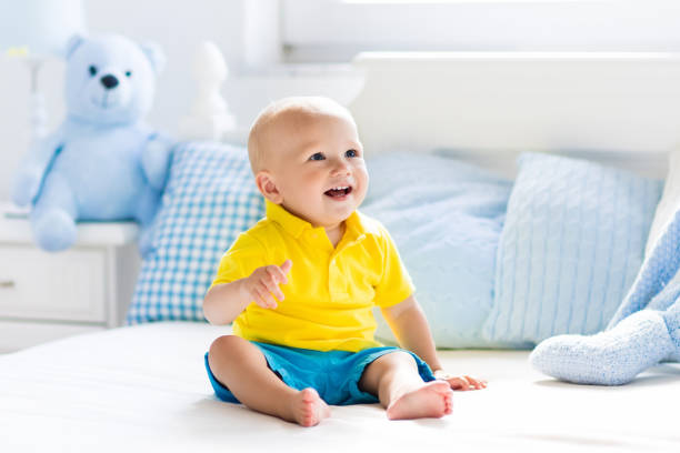 istock Baby boy playing on bed in sunny nursery 675010884